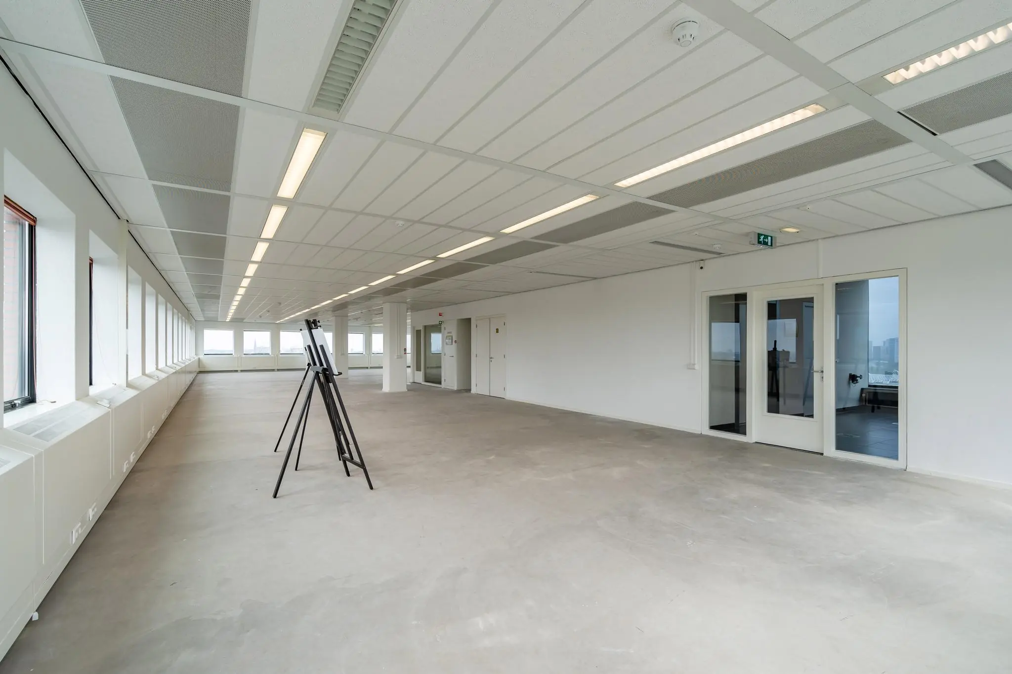 Leeg kantoorpand aan het Johanna Westerdijkplein met grote ramen en systeemplafond.